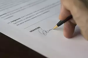 hand signing a legal document